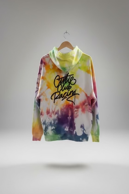 Colorful tie-dye hoodie with 'Cute Club Racing' text on a hanger against a neutral wall.